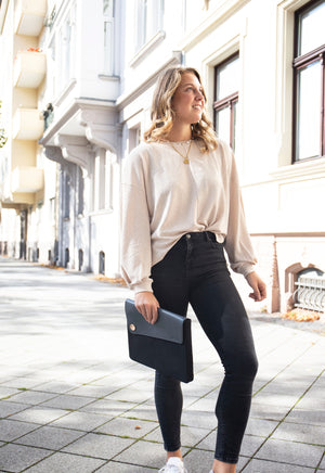 model holding black and grey laptop sleeves made of leather and canvas